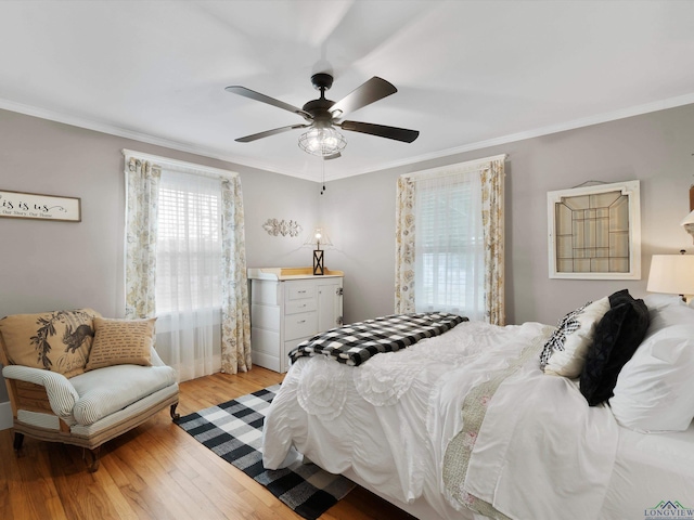 bedroom featuring ornamental molding, ceiling fan, and light wood-type flooring