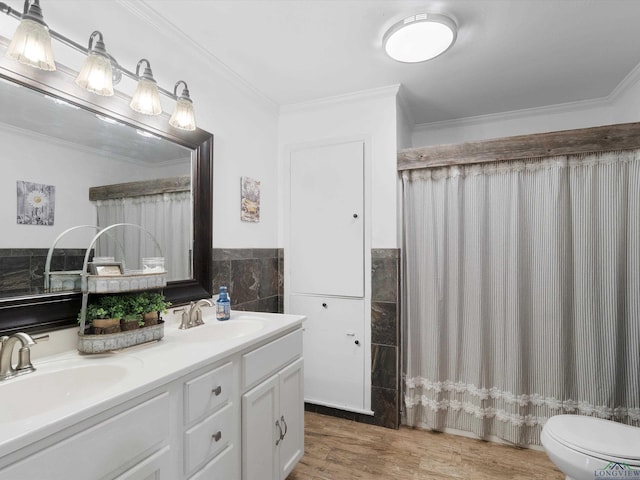 bathroom featuring tile walls, hardwood / wood-style flooring, vanity, toilet, and crown molding