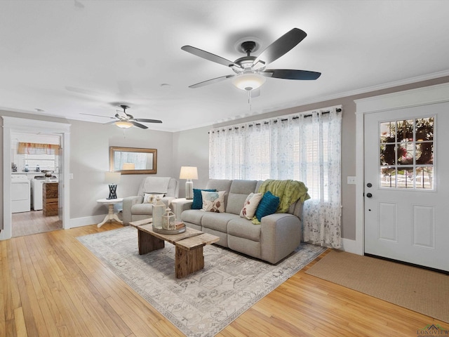 living room with washer / clothes dryer, crown molding, and hardwood / wood-style floors