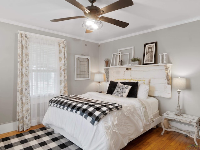 bedroom featuring hardwood / wood-style floors, ornamental molding, and ceiling fan