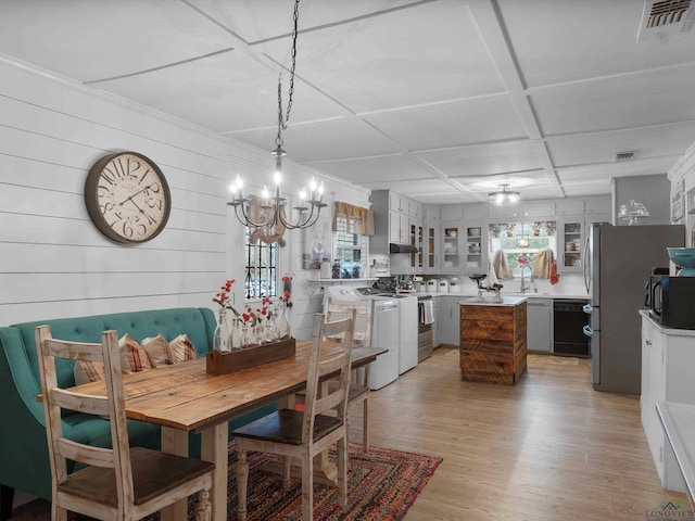 dining room with washing machine and clothes dryer, coffered ceiling, sink, a notable chandelier, and light hardwood / wood-style floors