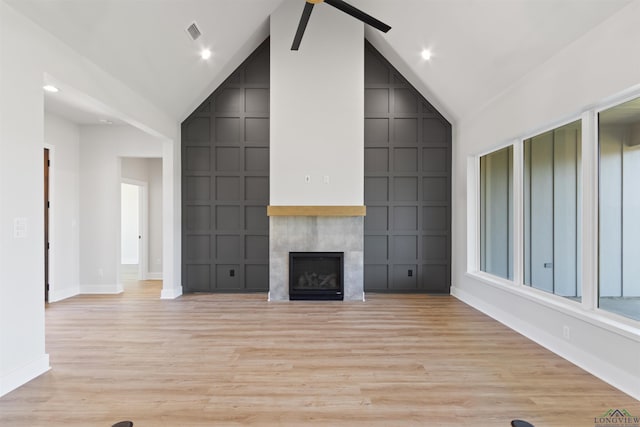 unfurnished living room with light hardwood / wood-style flooring and high vaulted ceiling