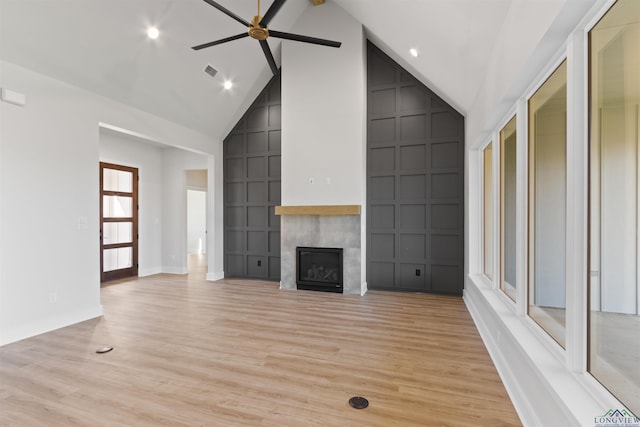 unfurnished living room featuring ceiling fan, beam ceiling, light wood-type flooring, and high vaulted ceiling