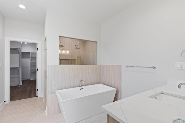 bathroom featuring tile patterned flooring, vanity, tile walls, and shower with separate bathtub