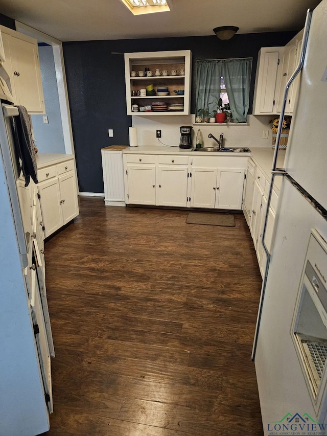 kitchen featuring dark hardwood / wood-style floors, white refrigerator, white cabinetry, and sink