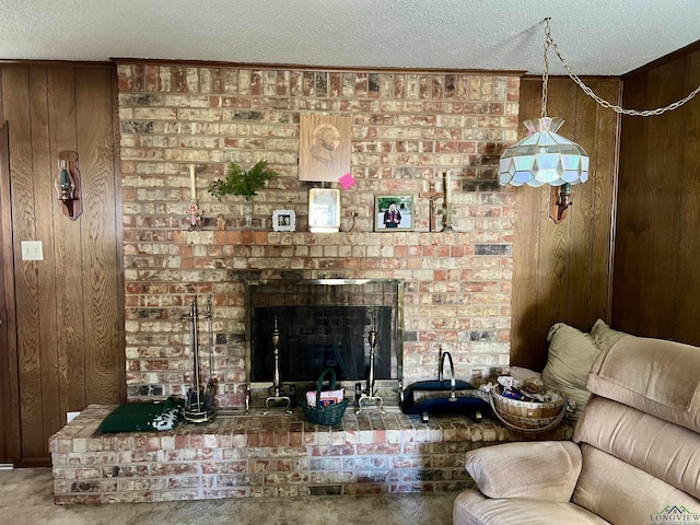 living room with a textured ceiling, a brick fireplace, wooden walls, and carpet flooring