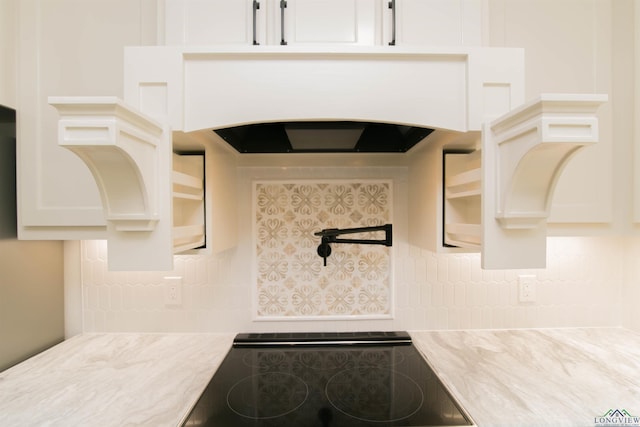 interior details featuring black electric stovetop and white cabinetry