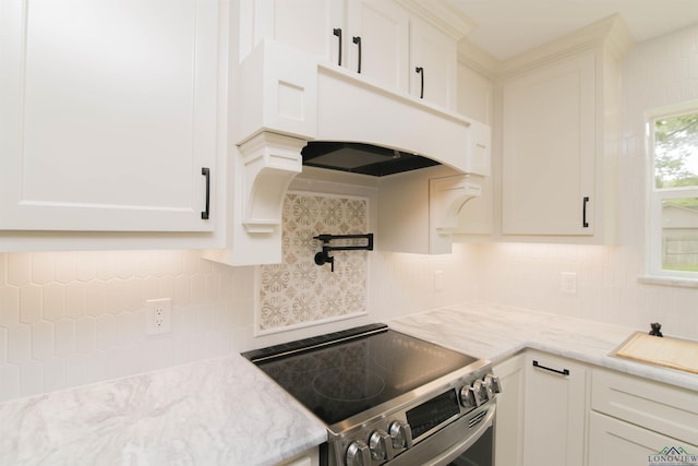 kitchen featuring stainless steel electric stove, white cabinetry, and tasteful backsplash