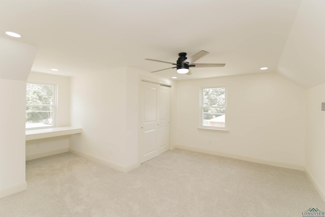 bonus room with ceiling fan, light carpet, and vaulted ceiling