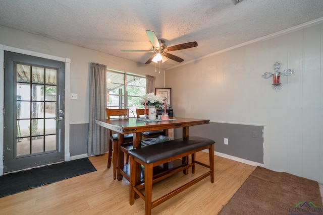 dining area with ceiling fan, light hardwood / wood-style flooring, and a textured ceiling