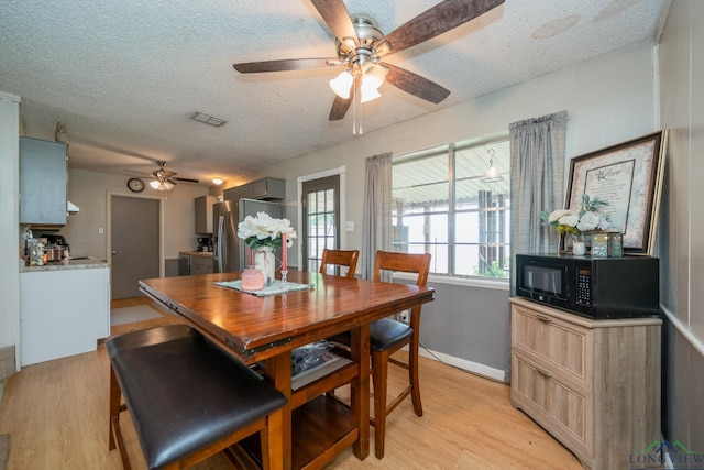 dining area featuring ceiling fan, a textured ceiling, and light hardwood / wood-style flooring