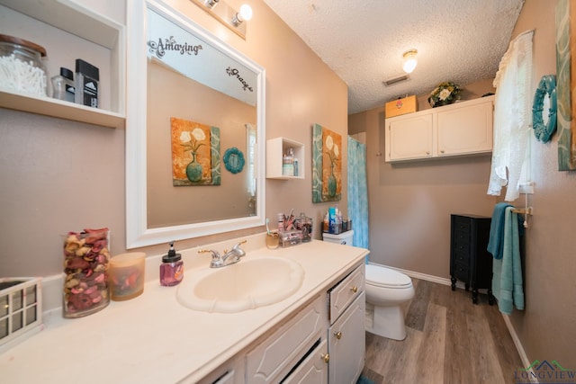 bathroom featuring hardwood / wood-style floors, vanity, a textured ceiling, and toilet