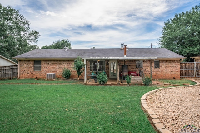 rear view of house with a patio, central AC, and a lawn