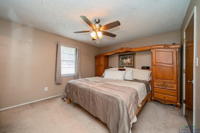 bedroom featuring ceiling fan, light carpet, and a textured ceiling