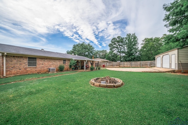 view of yard featuring an outbuilding, central AC, and an outdoor fire pit