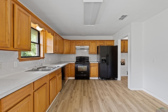 kitchen with black appliances, light wood-type flooring, sink, and tasteful backsplash