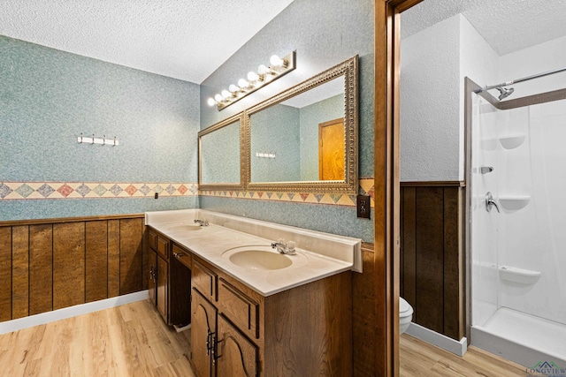 bathroom featuring walk in shower, toilet, a textured ceiling, and hardwood / wood-style flooring