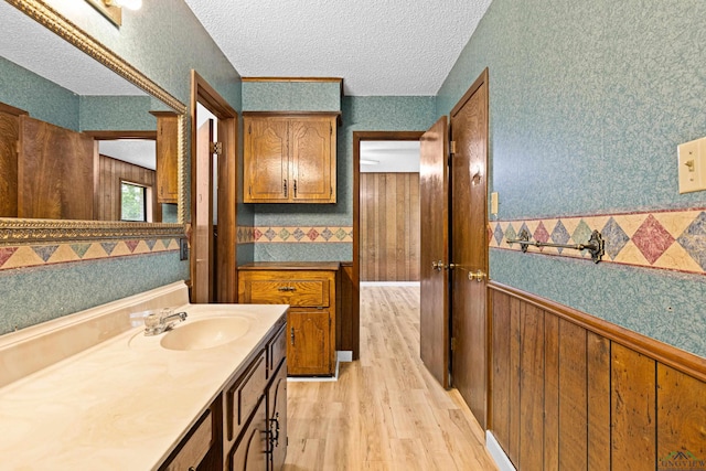 bathroom with vanity, a textured ceiling, and hardwood / wood-style flooring