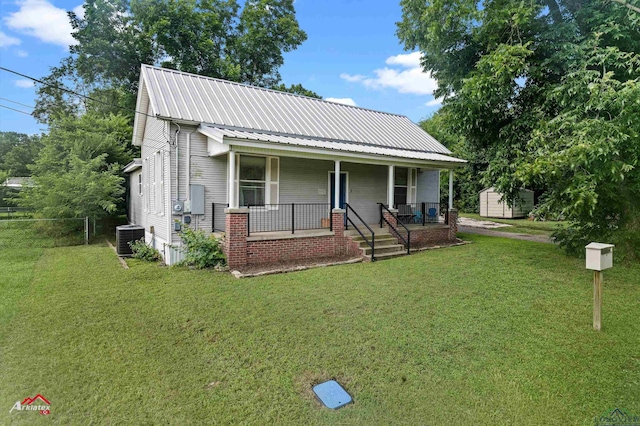 102 Poplar St, Marshall, TX 75670 - view of front of house with a porch, a front yard, a metal roof, and a shed