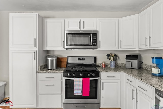 102 Poplar St, Marshall, TX 75670 - kitchen with stainless steel appliances, white cabinetry, and light stone countertops