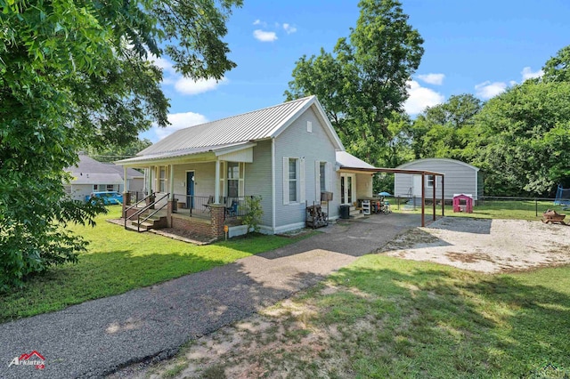 102 Poplar St, Marshall, TX 75670 - view of front of home featuring driveway, a porch, a carport, a storage shed, and a metal roof