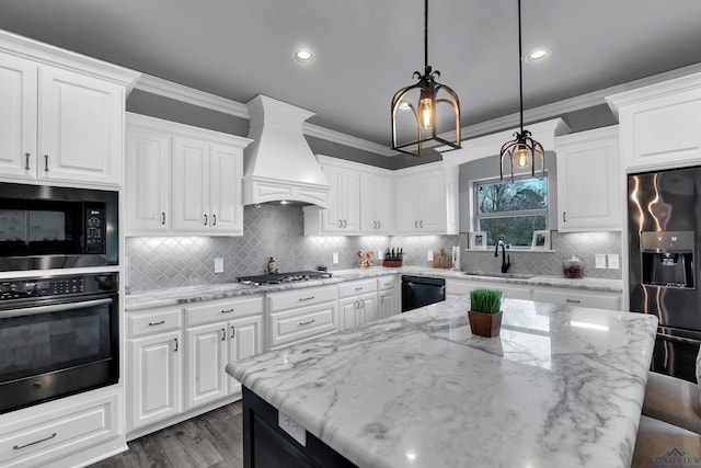 kitchen featuring pendant lighting, sink, white cabinets, custom exhaust hood, and stainless steel appliances