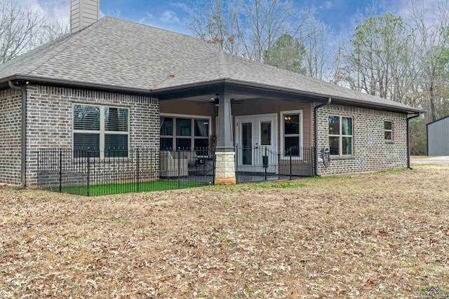 back of property featuring a yard and ceiling fan