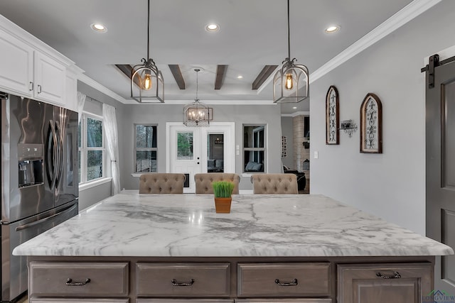 kitchen with hanging light fixtures, white cabinets, stainless steel fridge with ice dispenser, a barn door, and beamed ceiling