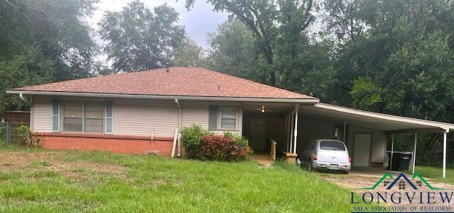 back of house with a carport and a lawn