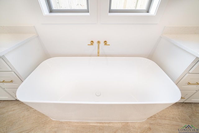 bathroom featuring a tub and a wealth of natural light