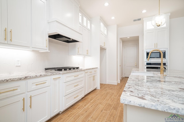 kitchen with white cabinets, pendant lighting, and stainless steel appliances