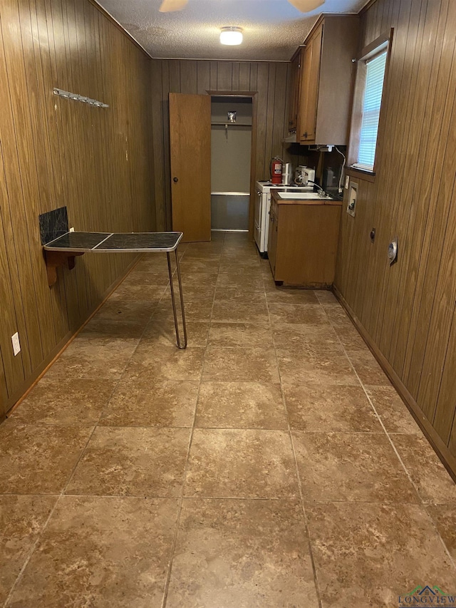 kitchen with a textured ceiling and wood walls