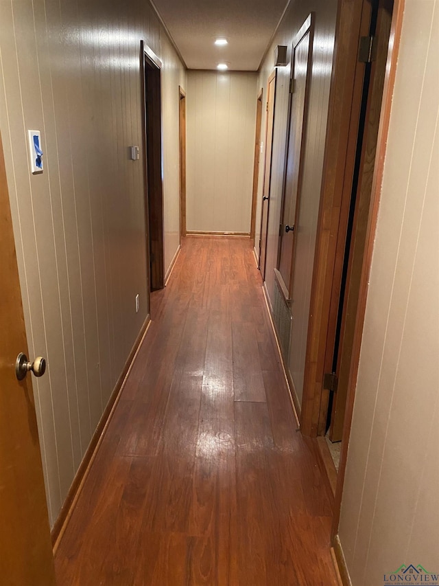 hallway with dark hardwood / wood-style flooring