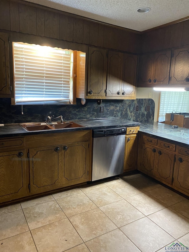 kitchen featuring sink, tasteful backsplash, a textured ceiling, light tile patterned floors, and stainless steel dishwasher