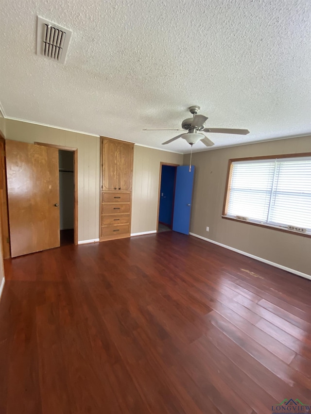 unfurnished bedroom with ceiling fan, dark wood-type flooring, and a textured ceiling