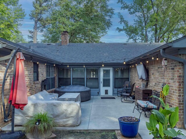 1317 Tiffany Ln, Longview, TX 75604 - back of house featuring a shingled roof, brick siding, a chimney, and a patio