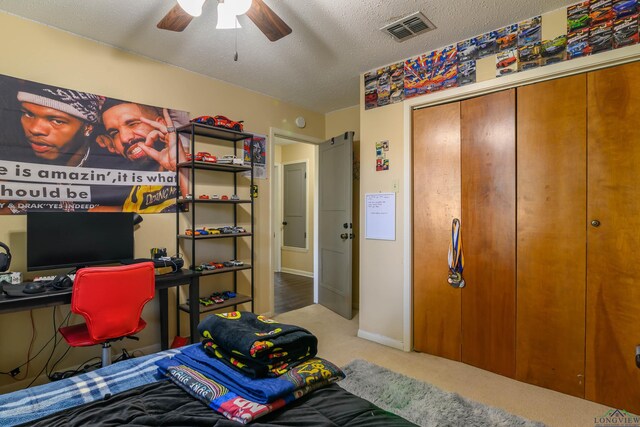 1317 Tiffany Ln, Longview, TX 75604 - bedroom with a desk, a textured ceiling, carpet floors, ceiling fan, and a closet