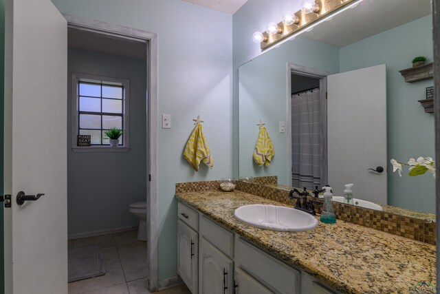 1317 Tiffany Ln, Longview, TX 75604 - full bath with toilet, vanity, tile patterned floors, and baseboards
