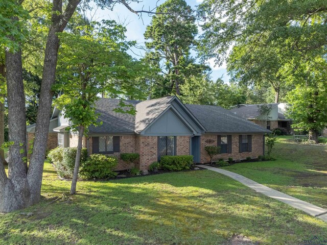 1317 Tiffany Ln, Longview, TX 75604 - view of front of house with brick siding, a front lawn, and roof with shingles