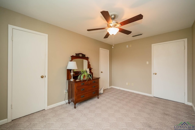 bedroom with visible vents, light colored carpet, a ceiling fan, and baseboards