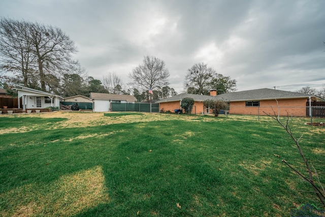 view of yard with a storage shed, an outdoor structure, and fence