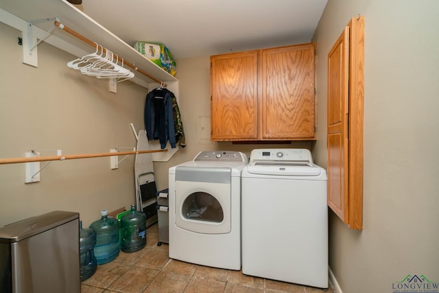 laundry room featuring washing machine and clothes dryer and cabinet space