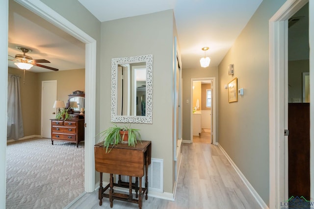 hallway with wood finished floors and baseboards