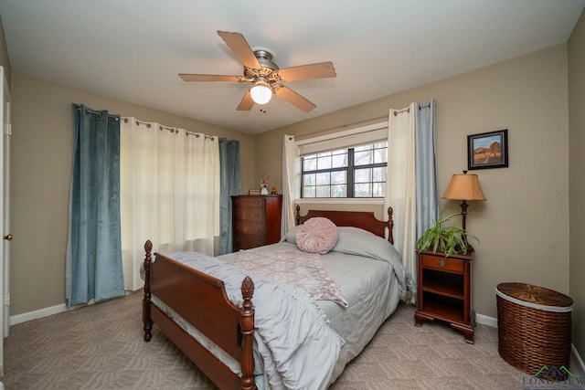 carpeted bedroom with baseboards and a ceiling fan