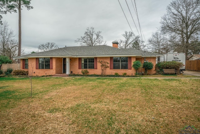 ranch-style home with brick siding, a chimney, a front yard, and fence