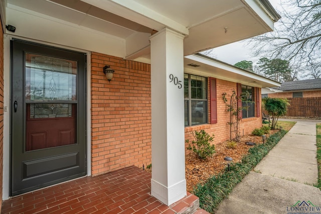 doorway to property featuring brick siding