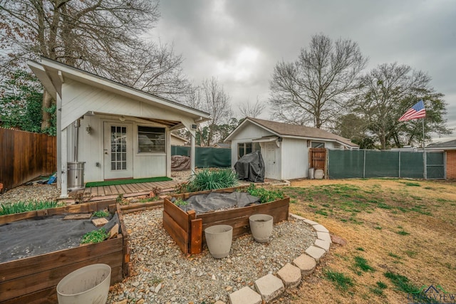 view of yard featuring a garden, an outbuilding, and a fenced backyard