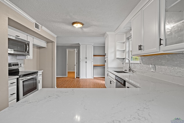 kitchen with light stone countertops, white cabinetry, sink, and stainless steel appliances