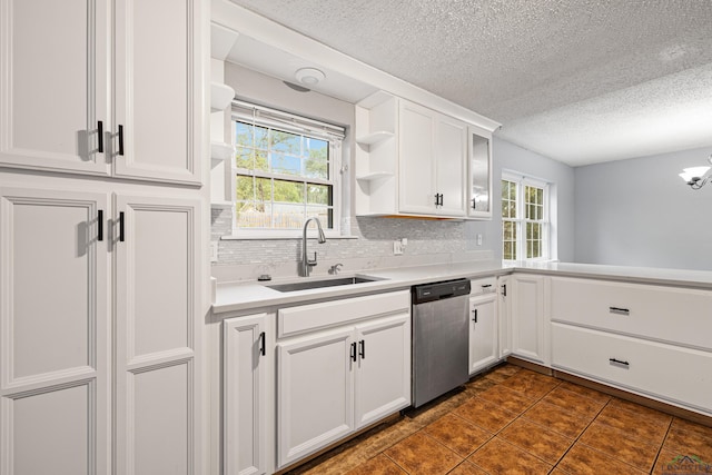 kitchen with backsplash, white cabinets, sink, dark tile patterned flooring, and dishwasher