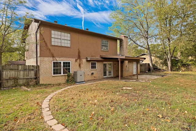 rear view of property featuring a yard, central AC, a patio area, and french doors